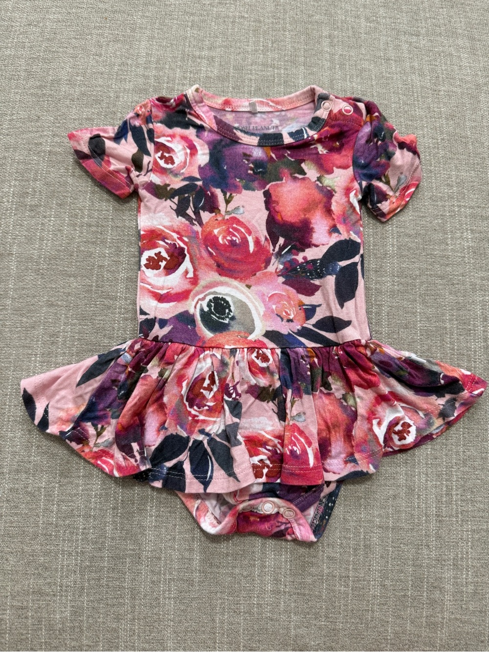 Posh Peanut twirl bodysuit features a Dusk Rose floral print 0-3M
